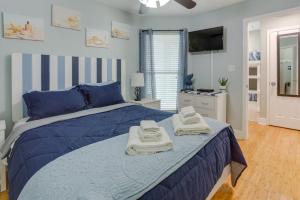 a bedroom with a blue bed with towels on it at Lovely Galveston Condo Walk to Seawall and Beach! in Galveston +17 photos