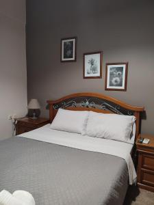 - une chambre avec un lit avec 2 tables de chevet et 2 photos dans l'établissement margarita home, à Kalamata