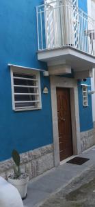 un edificio azul con puerta de madera y balcón en CIVICO 33, en Bisceglie
