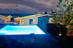 una gran piscina azul frente a una casa en Villa avec piscine à 450m des plages, en Sainte-Luce