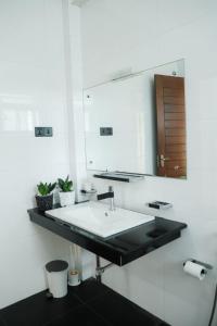 uma casa de banho branca com um lavatório e um espelho em Villa Water View em Bandaragama