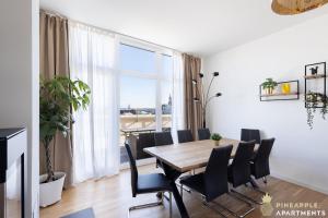 une salle à manger avec une table, des chaises et une grande fenêtre dans l'établissement Pineapple Apartments Penthouse am Zwinger - 162 qm - 1x free parking, à Dresde