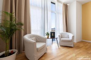 un soggiorno con 2 sedie e un tavolo di Pineapple Apartments Penthouse am Zwinger - 162 qm - 1x free parking a Dresda