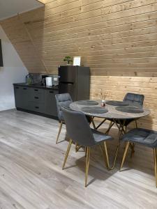une salle à manger avec une table et des chaises et une cuisine dans l'établissement Casa de lemn 1,Tip A, à Corbu