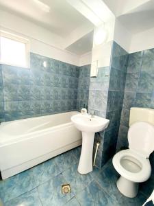 a bathroom with a toilet and a tub and a sink at VILA SIXTY-NINE in Eforie Sud