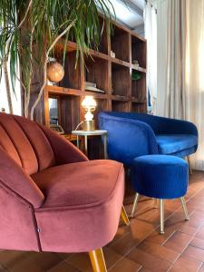 a living room with a couch and a blue chair at Logis Hôtel Médiéval, Montélimar Nord in Rochemaure