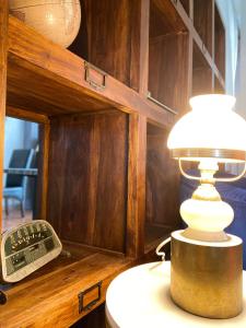 a lamp sitting on a table next to a telephone at Logis Hôtel Médiéval, Montélimar Nord in Rochemaure