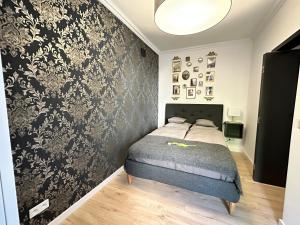 a bedroom with a bed and a black and white wall at Main Square Apartments Sylvi in Krakow