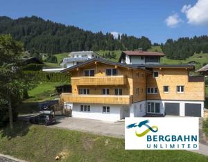 ein Haus auf einem Hügel mit einem Schild in der Unterkunft Ferienwohnung Riezler in Hirschegg