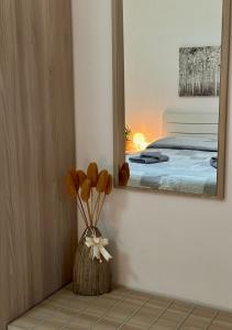 een kamer met een spiegel en een vaas met bloemen bij Casa Lucia 9a in Monopoli
