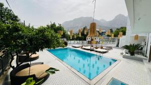 una piscina en la parte superior de un edificio con montañas en el fondo en GÜLER BUTİK HOTEL, en Antalya
