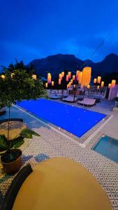 uitzicht op een zwembad in de nacht bij GÜLER BUTİK HOTEL in Antalya
