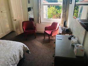 伊爾弗勒科姆的住宿－瓦利屋酒店，卧室配有两把椅子、一张桌子和一张床