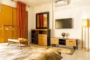 una camera con TV, cassettiera e letto di L'appartement Alpha Dakar a Dakar Altre 30 foto