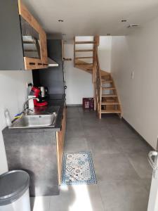 eine Küche mit einem Waschbecken und einer Treppe in der Unterkunft Appartement 6 personnes au calme à 25minutes de disney in Giremoutiers