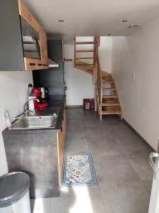 a kitchen with a sink and a stair case at Appartement 6 personnes au calme à 25minutes de disney in Giremoutiers