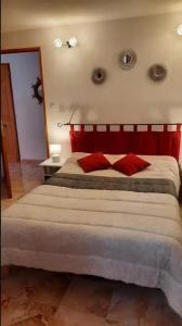een slaapkamer met een groot bed met een rood hoofdeinde bij Maison d'une chambre avec jardin amenage et wifi a Caseneuve in Caseneuve