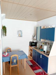 a kitchen with blue cabinets and a table at Haus Hinzberg in Oberhof