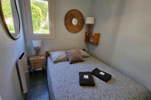 - une petite chambre avec un lit et un miroir dans l'établissement Beautiful house with pool and sea view, à Saint-Mandrier-sur-Mer