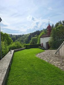 a person riding a bike in a grassy yard with a building at Zimmer-B&B Restaurant Wirtshaus zur Trostburg in Teufenthal