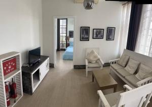 a living room with a couch and a tv at Cozy 1BR in Downtown Phnom Penh BKK2 in Phnom Penh