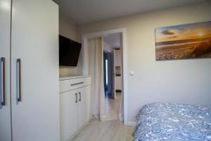 Un dormitorio con una cama y un televisor de pantalla plana. en Nautic Lounge - Beach House 2, en Haffkrug