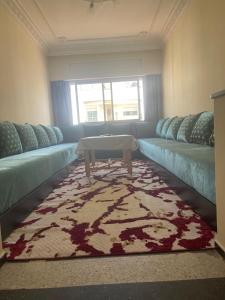 een woonkamer met een bank en een salontafel bij Charmant appartement à Hassan in Rabat