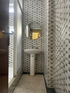 La salle de bains est pourvue d'un lavabo et d'un miroir. dans l'établissement Charmant appartement à Hassan, à Rabat