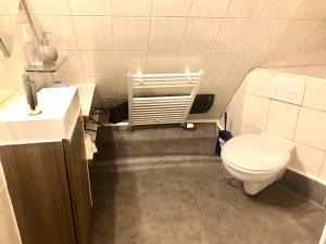uma casa de banho com um WC branco e um lavatório. em Penthouse em Braunschweig
