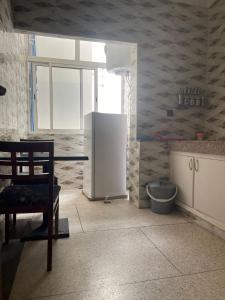 Il comprend une cuisine équipée d'un réfrigérateur et d'une fenêtre. dans l'établissement Charmant appartement à Hassan, à Rabat