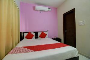 a bedroom with a large bed with red pillows at Flagship Manu Residency Near Ascendas Park Square Mall in Bangalore