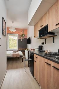 a kitchen with wooden cabinets and a table with a window at BLIŻEJ GÓR Jedlina-Zdrój. Apartament na 5 in Jedlina-Zdrój