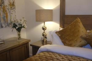a bedroom with a bed with a lamp and a vase of flowers at The Barrington Guesthouse Hotel in Scarborough