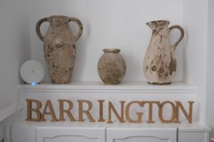 cuatro jarrones sentados en la parte superior de un estante con la palabra permiso en The Barrington Guesthouse Hotel, en Scarborough
