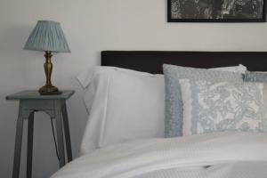スカーバラにあるThe Barrington Guesthouse Hotelのベッド(白いシーツ、テーブルの上にランプ付)