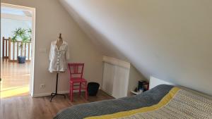 a bedroom with a bed and a red chair at Casa DAMG in Loucelles