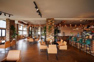 un restaurante con mesas y sillas y un bar en Felinger Collection Hotel & SPA, en Ereván