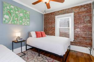 a bedroom with two beds and a brick wall at Entire Complex with 4 bedrooms and 9 beds in Kansas City