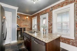 a kitchen with a sink and a brick wall at Entire Complex with 4 bedrooms and 9 beds in Kansas City