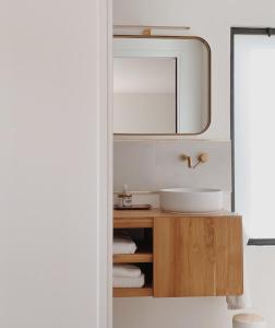 une salle de bain avec un lavabo et un miroir dans l'établissement L'Atelier d'ici, à Thomery