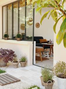 d'une terrasse avec des plantes en pot et une table. dans l'établissement L'Atelier d'ici, à Thomery