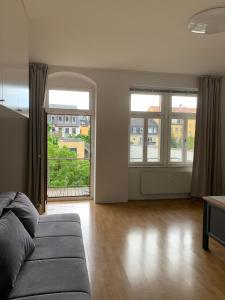 a living room with a couch and two windows at Ferienwohnung für kleine und große Reisegruppe in Dresden