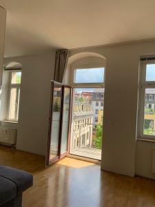 an empty living room with two windows and a large door at Ferienwohnung für kleine und große Reisegruppe in Dresden