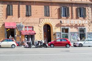 um edifício com carros e motos estacionados em frente em Musa Rooms Roma em Roma