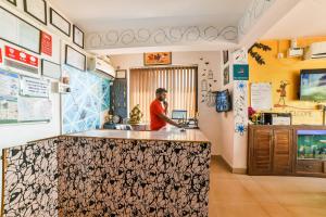 瓦斯科達伽馬的住宿－Dewa Goa Hotel Near Dabolim Airport，站在厨房柜台上的人