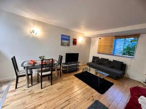 ein Wohnzimmer mit einem Tisch und einem Sofa in der Unterkunft Chelsea Studio Apartment - Sleeps 4 - near Cromwell Hospital in London