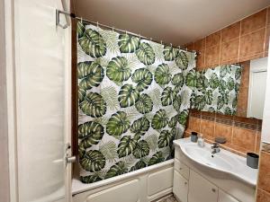 ein Badezimmer mit einem Duschvorhang mit grünen Blättern in der Unterkunft Chelsea Studio Apartment - Sleeps 4 - near Cromwell Hospital in London