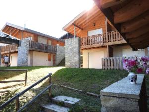 a house with a porch and a balcony on it at Les Chalets Petit Bonheur - Chalets pour 6 Personnes 504 in Villarodin-Bourget