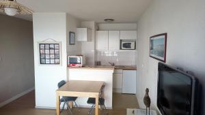a kitchen with a table and a tv in a room at Face à la mer by Corinne in Mers-les-Bains +27 photos