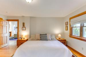 a bedroom with a large white bed with two lamps at Chic Addison Home with Fire Pit on 8 Private Acres! in Milbridge